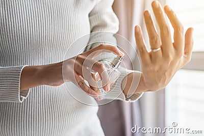 Woman hands applying bottle of her favorite perfume at home Stock Photo