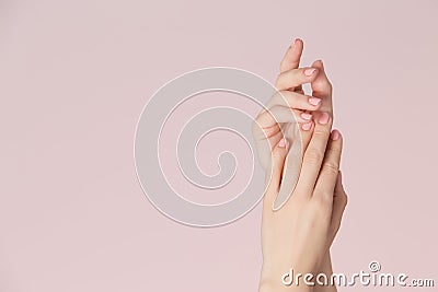 Woman hands with clean skin and nails with pink polish manicure on pink background. Nails care and beauty theme. Stock Photo