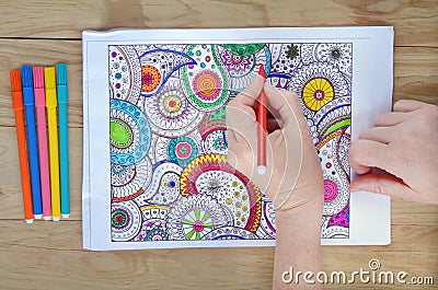 Woman hands coloring patterns on a coloring page for stress rel Stock Photo
