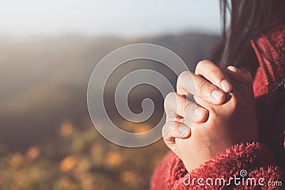 Woman hands folded in prayer in beautiful nature background Stock Photo