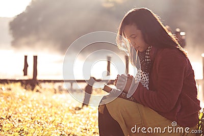 Woman hands folded in prayer on a Holy Bible for faith Stock Photo