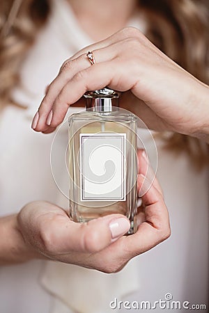 Woman hands holding bottle of perfume Stock Photo