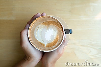 Woman hands holding coffee cup with latte art in the morning tim Stock Photo