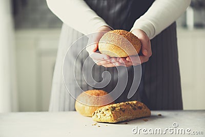 Woman hands holding freshly baked bread. Bun, cookie, bakery concept, homemade food, healthy eating. Copy space. Banner. Stock Photo