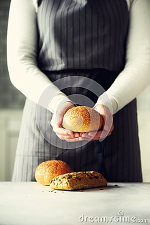 Woman hands holding freshly baked bread. Bun, cookie, bakery concept, homemade food, healthy eating. Copy space. Banner. Stock Photo