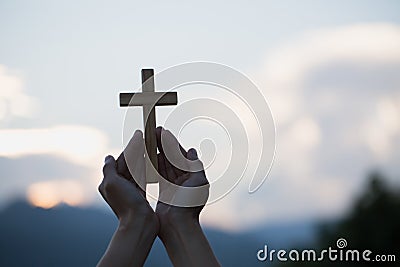 Woman hands holding holy lift of christian cross with light suns Stock Photo