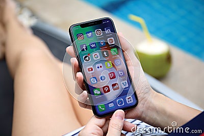 Woman hands holding iPhone X with social network on screen Editorial Stock Photo