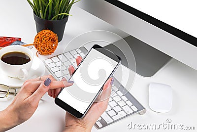 Woman hands holding the phone with isolated screen and cup of coffee. Business workplace with computer, glasses and business Stock Photo