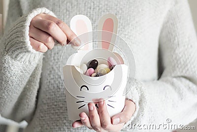 Woman hands holding rabbit box with Easter sweets inside Stock Photo