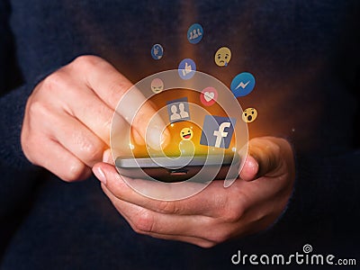 Woman hands holding and using smartphone mobile cell phone check Facebook social media network app. Editorial Stock Photo