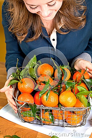 Woman hands with iron basket with fresh clementine copy space Stock Photo