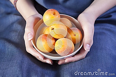 The Woman hands keeping crockery with mellow apricots Stock Photo