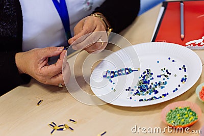 Woman hands making bead bracelet Stock Photo