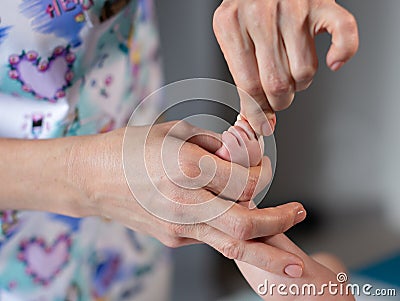 Woman hands massaging baby leg Stock Photo