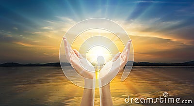 Hands with spark of hope, the light of faith sunset background Stock Photo