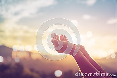 Woman hands place together like praying in front of nature green background. Stock Photo