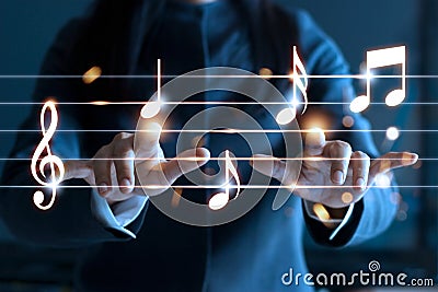 Woman hands playing music notes on dark background, Stock Photo