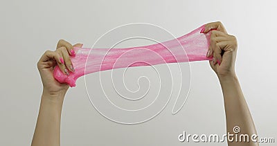 Woman hands playing oddly satisfying pink slime on white background. Antistress Stock Photo