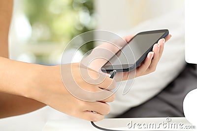Woman hands plugging a charger in a smart phone Stock Photo