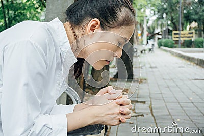 Woman hands praying with a bible in her knees outdoors Stock Photo