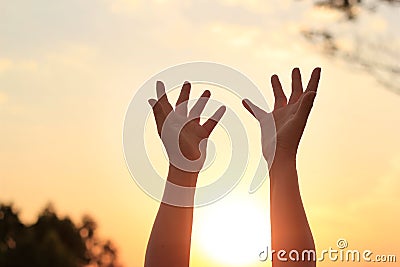 Woman hands praying for blessing on sunset background Stock Photo