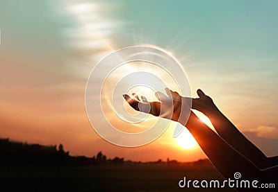 Woman hands praying on sunset background Stock Photo