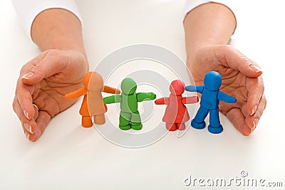 Woman hands protecting clay people family Stock Photo