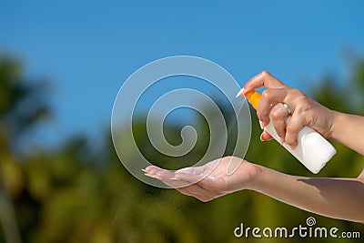 Woman hands putting sunscreen from a suncream bottle Stock Photo