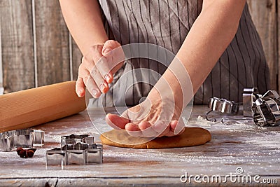 Woman hands rolls up the gingerbread dough on the table Stock Photo