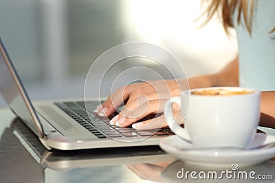 Woman hands typing in a laptop in a coffee shop Stock Photo