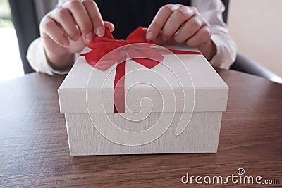 Woman hands wrapping gift box, unwrap or open present Stock Photo