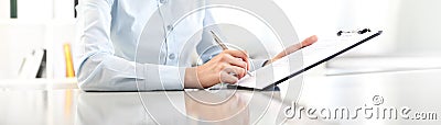 Woman hands writing on clipboard with a pen, isolated on desk Stock Photo