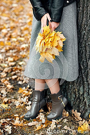 Woman hands with yellow leaves closeup. Fall season in city park Stock Photo