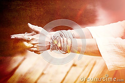 Woman hands in yoga symbolic gesture mudra lot of bracelets and Stock Photo