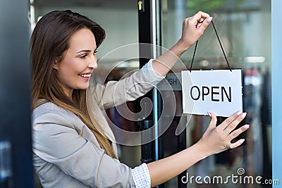 Woman hanging open sign on door Stock Photo