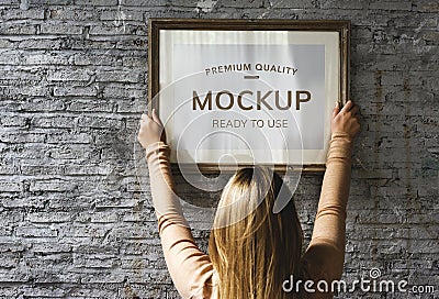 Woman hanging a photo frame mockup Stock Photo