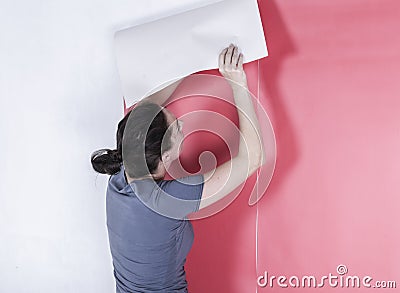 Woman hanging wallpaper Stock Photo