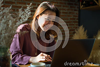 A woman is typing a message on her laptop Stock Photo