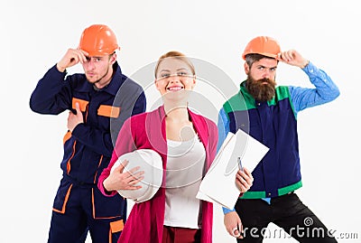 Woman with hard hat and smiling face manages mens team Stock Photo