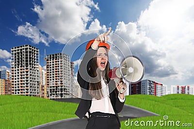 Woman in hardhat screaming in megaphone Stock Photo