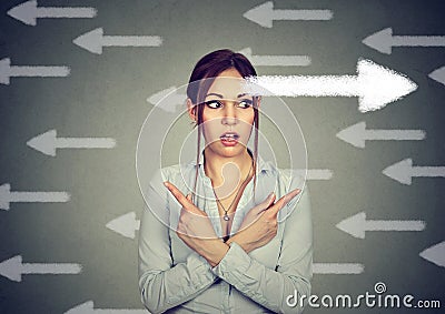 Woman has second thought perplexed pointing fingers in different direction Stock Photo