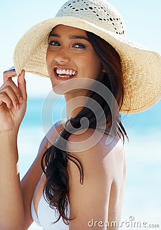 Woman, hat and happy at beach in portrait, nature and traveling to ocean for peace on vacation. Female person, outdoors Stock Photo