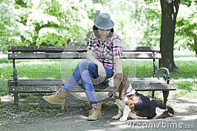 Woman with a hat in the park enjoying with her dear dog Stock Photo