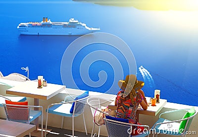 Woman in hat sitting in cafe and enjoys views of the Caldera and cruise ship, Santorini, Fira, Greece Editorial Stock Photo