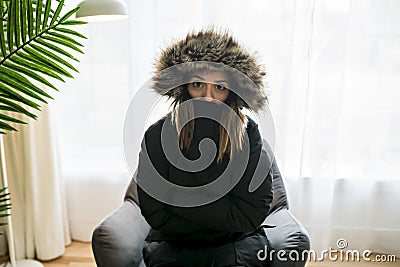 Woman have cold on the sofa at home with winter coat Stock Photo