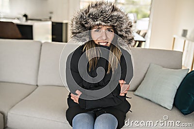 Woman have cold on the sofa at home with winter coat Stock Photo