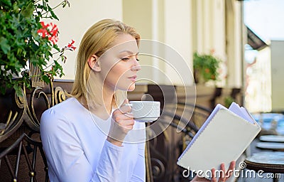 Woman have drink cafe terrace outdoors. Find opportunity to read more. Girl drink coffee while read bestseller book by Stock Photo