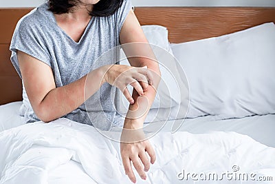 woman have problem with dust mites allergy bedding hand scratching her itchy and rash skin Stock Photo