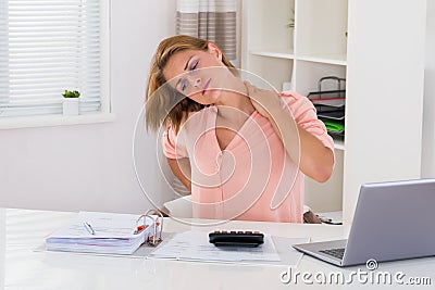 Woman Having Neckache At Desk Stock Photo