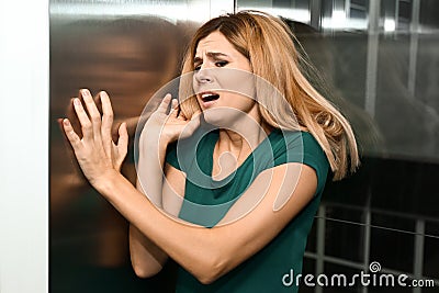 Woman having panic attack in elevator Stock Photo